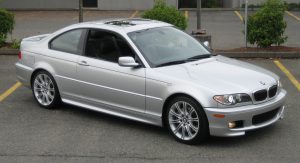 Silver BMW E46 coupe parked in a lot, showcasing its sporty design.